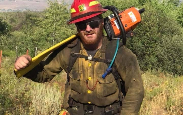 tree service worker carrying a chainsaw